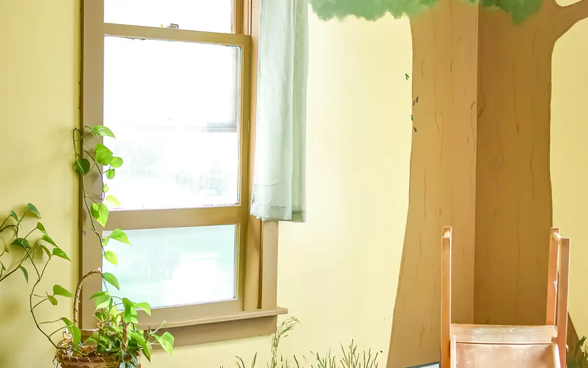 A sunlit window in the South Royalton Health Center waiting area, with a trailing houseplant and a child-sized chair